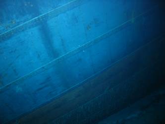 Wreckage hanging over port side of well deck